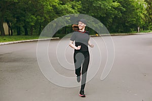 Young smiling athletic beautiful brunette girl in black uniform, cap training doing sport exercises, running, jogging