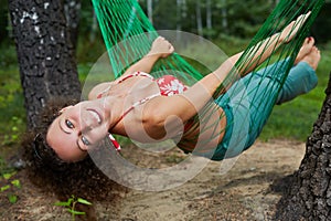 Young smiling barefooted woman swing in hammock photo