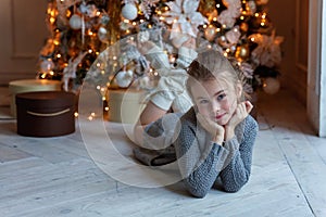 Young girl lies near a Christmas tree