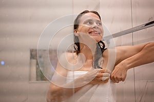 Young smiling beautiful happy woman wrapped in white bath towel after shower