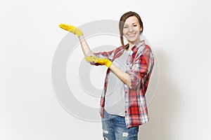 Young smiling beautiful woman in casual clothes, building yellow gloves pointing hands aside on copy space isolated on