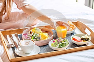 Young Smiling Beautiful Woman Having Breakfast in Bed in Cozy Hotel Room