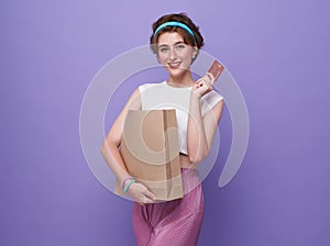 Young smiling beautiful woman presenting credit card in hand showing trust and confidence for making payment