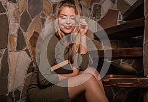 Young smiling beauty woman with books against house interior.