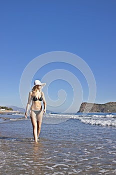 Young smiling blond woman in black bikini