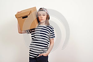 Young smiling boy holding the box on white background. Child with carton package. Delivery Concept