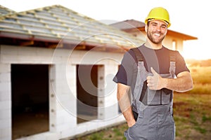 Young smiling builder gesture with his thumb up. Toned