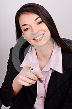 Young smiling business woman pointing finger at viewer