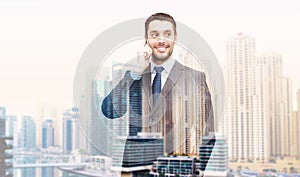 Young smiling businessman calling on smartphone