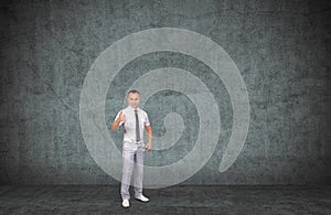 Young smiling businessman showing thumbs up sign