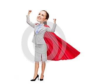 Young smiling businesswoman in red superhero cape