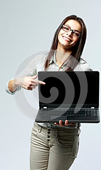 Young smiling businesswoman showing on a laptop screen