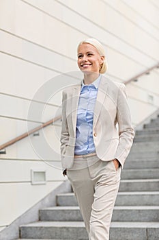 Young smiling businesswoman walking down stairs