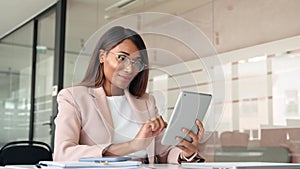Young smiling busy business woman manager using tablet in office.