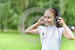 Young smiling caucasian girl listening music with professional DJ headphones and getting fun