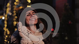 Young smiling caucasian girl wearing winter hat,looking satisfied walking happily and rejoicing at the Christmas