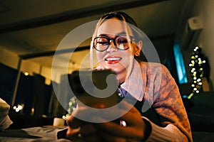 Young smiling caucasian woman using mobile phone in holidays at home on the bed