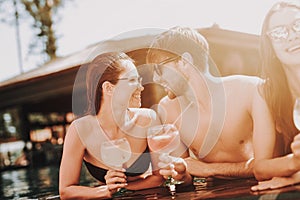 Young Smiling Couple with Cocktails at Poolside