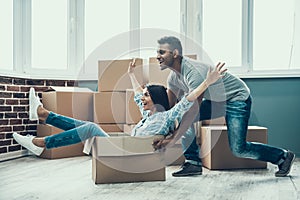 Young Smiling Couple Having Fun Unpacking Boxes