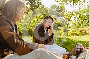 Young smiling couple in love enjoying picnic time in park