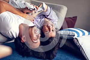 Young smiling couple playing videogames at home.