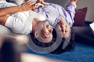 Young smiling couple playing videogames at home.