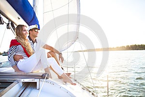 Young smiling couple on a sailing boat at summer