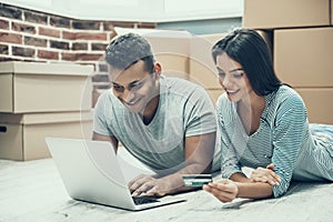 Young Smiling Couple Shopping Online on Laptop