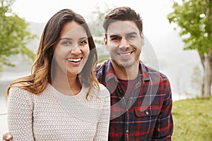 Young smiling couple sitting a park, portrait