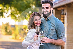 Young smiling couple tasting wine at winery outdoors