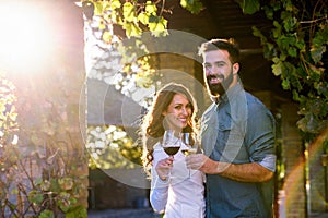 Young smiling couple tasting wine at winery outdoors