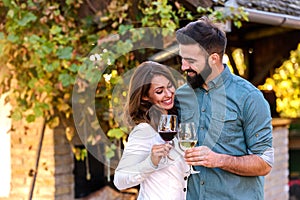 Young smiling couple tasting wine at winery outdoors