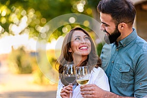 Young smiling couple tasting wine at winery outdoors