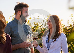 Young smiling couple tasting wine at winery outdoors