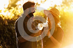 Young smiling couple tasting wine at winery vineyard