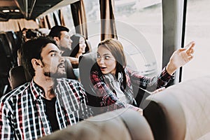 Young Smiling Couple Traveling on Tourist Bus photo