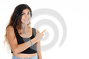 Young smiling cute woman pointing side hand finger at copyspace looks in camera