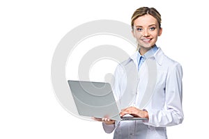 young smiling doctor in white coat holding laptop