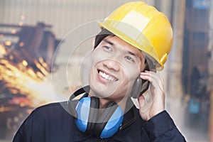 Young Smiling Engineer on the Phone wearing a Hardhat, On Site