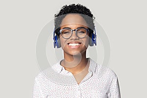 Young smiling ethnic girl listening to favorite music.