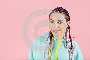 Young smiling fashionable woman with braids kanekalon. Colored artificial strands of hair