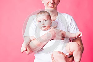 Young smiling father holding baby in his arms