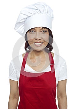 Young smiling female chef wearing red apron