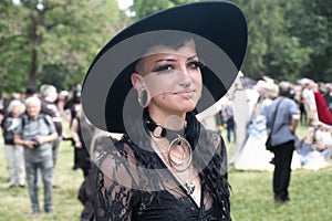 Young, smiling, female goth in black outfit on the annual Wave Gotik Treffen