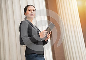 Young smiling female lawyer holding mobile pad