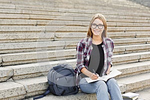 Young student girl making notes in notebook