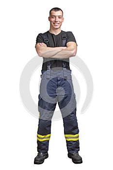 Young smiling firefighter with folded arms wearing black t-shirt and fireproof pants with suspenders