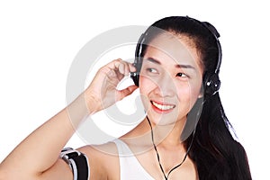 Young smiling fitness woman listening to music with earphones is