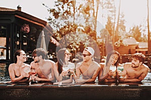 Young Smiling Friends with Cocktails at Poolside