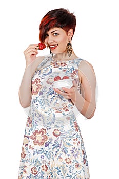 Young smiling girl eating strawberries.